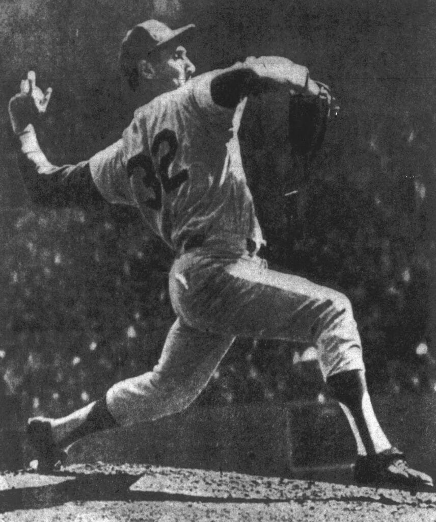 Black-and-white photo of Sandy Koufax in full extension delivering a pitch in Game 1 of the 1963 World Series, a key chapter in Dodgers World Series history.