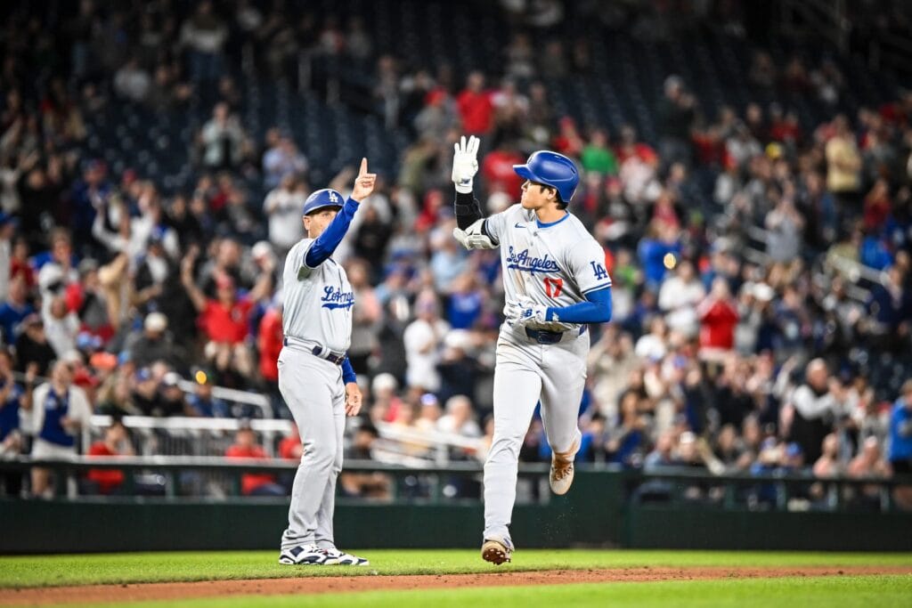 Shohei Ohtani and a Dodgers teammate celebrating on the field after his home run.