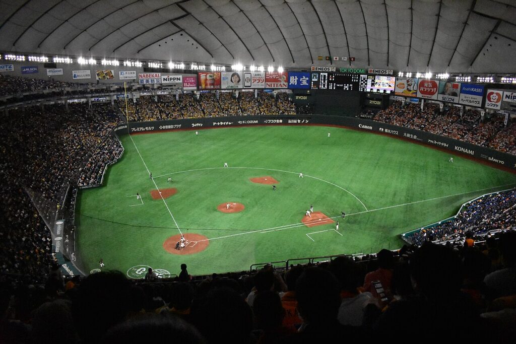 Wide view of the Tokyo Dome interior during a baseball game, with fans filling the stands around the field